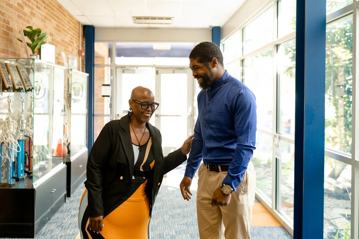 Angelia Moore talking with an educator in a school hallway