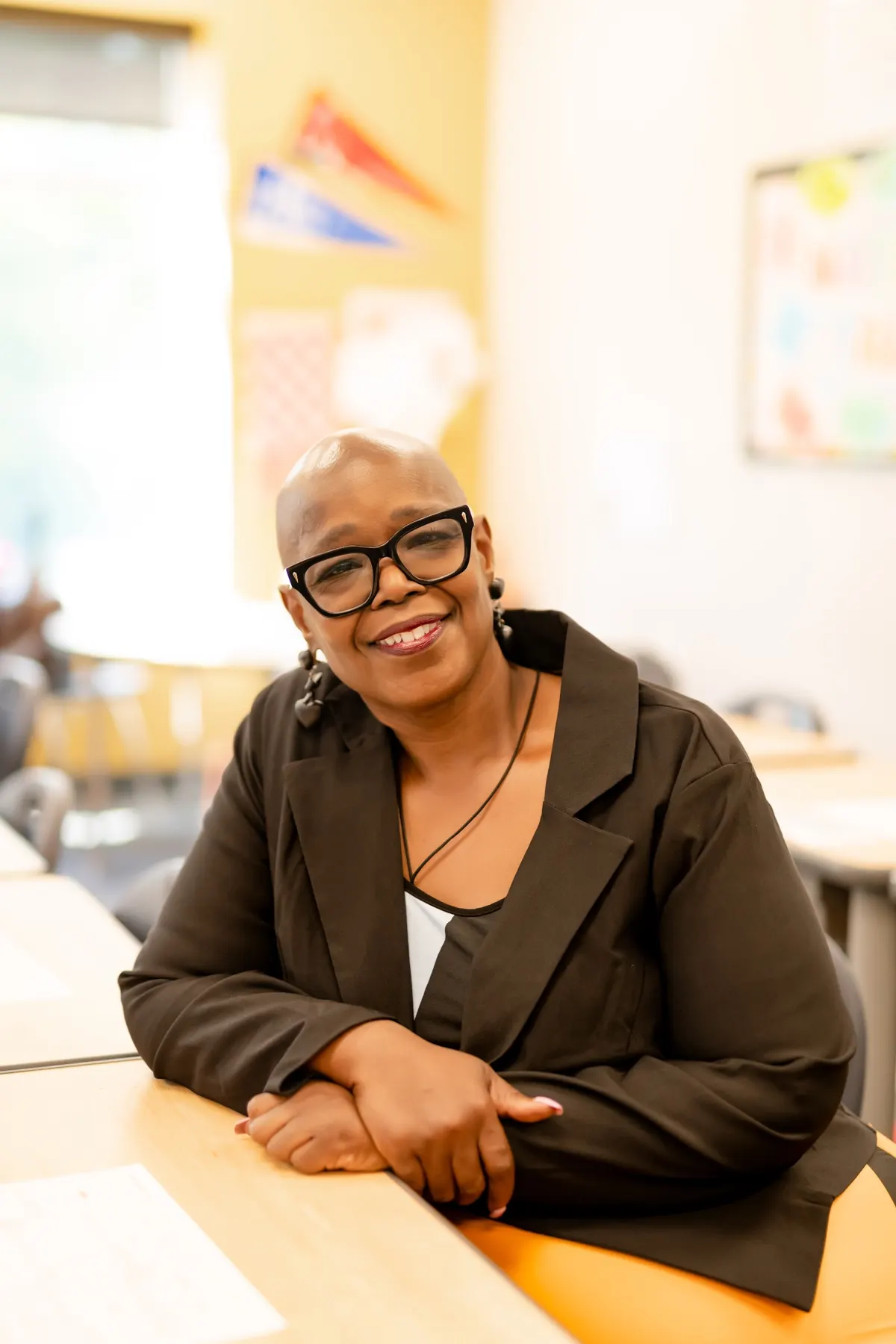 Angelia Moore smiling at a desk in a bright classroom